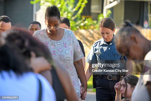 Kansas City Police Chief Stacey Graves held hands with Cherron Barney, left, and another woman as people gathered in the street to pray after three...