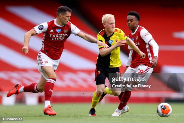 Will Hughes of Watford is challenged by Granit Xhaka and Joe Willock of Arsenal during the Premier League match between Arsenal FC and Watford FC at...
