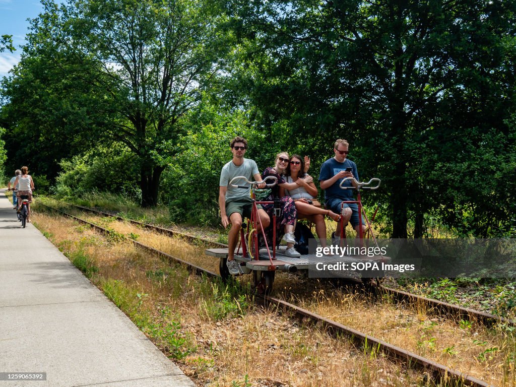 Over Bike Riding A family seen riding a special bike over a train track on a very hot ...