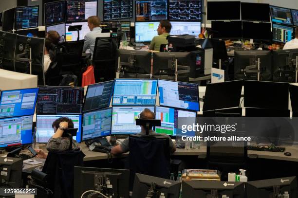 June 2023, Hesse, Frankfurt/Main: Stock traders sit in front of their monitors in the trading hall of Deutsche Börse. The German benchmark index DAX...