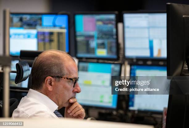 June 2023, Hesse, Frankfurt/Main: A stock trader follows the price development on his monitors in the trading room of Deutsche Börse. The DAX,...