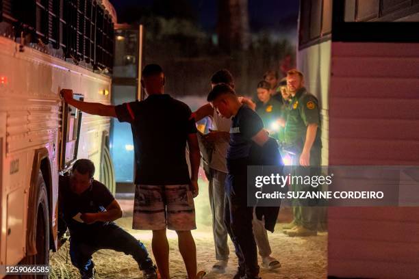 Border Patrol agents escort migrants onto a bus to be taken to a processing facility to begin their asylum-seeking process in Eagle Pass, Texas on...