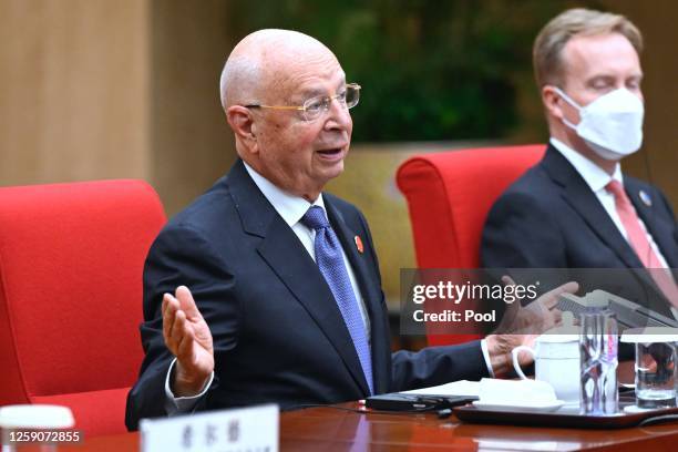 Founder and executive chairman of the World Economic Forum, Klaus Schwab speaks with Chinese Premier Li Qiang during their bilaterial meeting ahead...