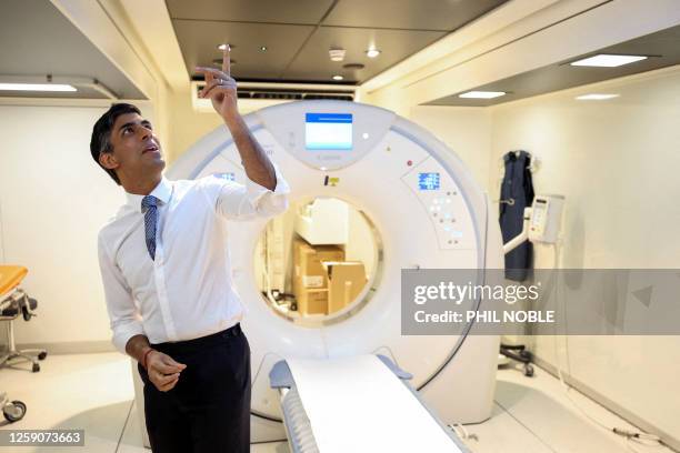 Britain's Prime Minister Rishi Sunak points to the ceiling as he visits a mobile lung health check unit in Nottingham, central England on June 26,...