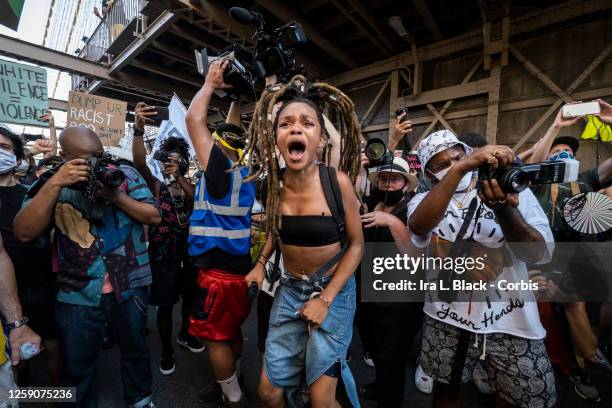 July 25: Livia Rose Johnson an organization leader of Warriors In the Garden jumps up and screams into a microphone as she leads the crowd of...