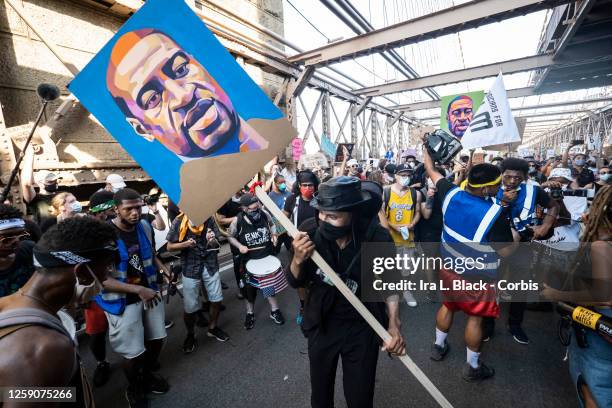 July 25: Thousands of protesters wearing masks and holding signs and painted portraits of George Floyd dancing on the walk across the Brooklyn Bridge...