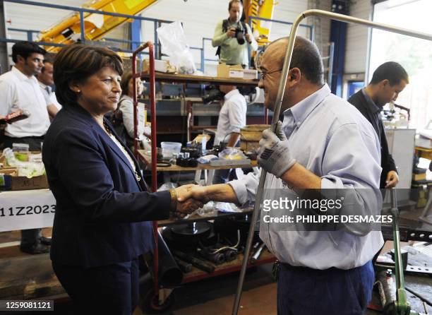 French candidate fot the socialist nomination for next year's presidential vote, Martine Aubry shakes hand to a worker at the Hydro 3M factory during...