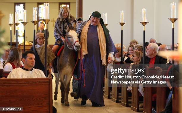 Eleven-year-old Lucas Lottinger as "Joseph" left, ten-year-old Annabel Skubisz as "Mary" center, rides a donkey with the help of Todd Vlasak right,...