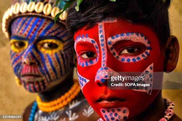 Two children pose with their faces painted as part of their Impersonating Act on the theme of different Tribal Cultures. For generations Bahurupi...
