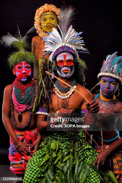 Man poses with his children with their faces painted as a part of their Impersonating Act on the theme of different Tribal Cultures. For generations...