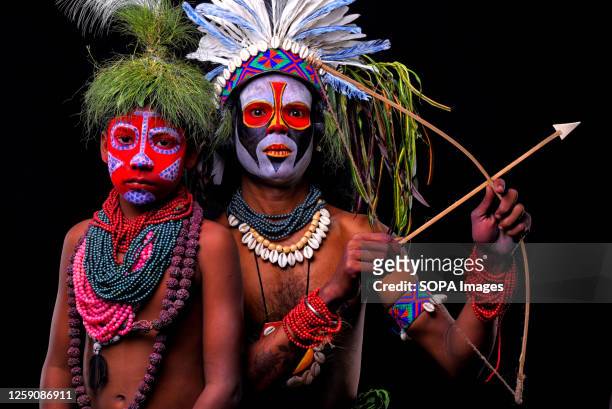 Bahurupi artist and his son poses with their faces painted as a part of their Impersonating Act on the theme of different Tribal Cultures. For...