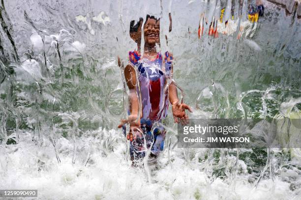 Young boy plays in the water fountain at Yards Park in Washington, DC, on June 26, 2023 as a heatwave settles in on the area.