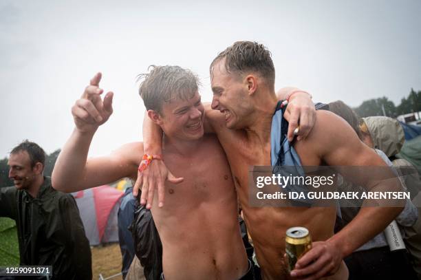 Revellers dance in the rain at the Roskilde Music Festival, west of Copenhagen, Denmark on June 26, 2023. / Denmark OUT