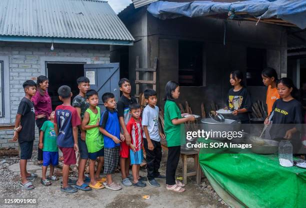 Children wait in a queue to receive food at a relief camp in Rengkia village. On May 3 ethnic conflict erupted in the northeastern Indian state of...