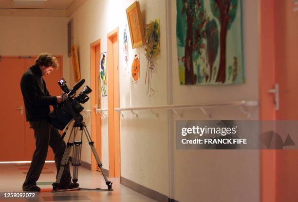 Une personne filme des dessins d'enfants accrochés dans un couloir de l'Institut médico-éducatif Christian-Lazard de la Queue-les-Yvelines, le 05...