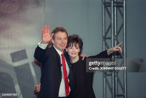 Labour Party leader and new British Prime Minister Tony Blair and his wife Cherie Blair wave and smile at party workers and supporters after their...