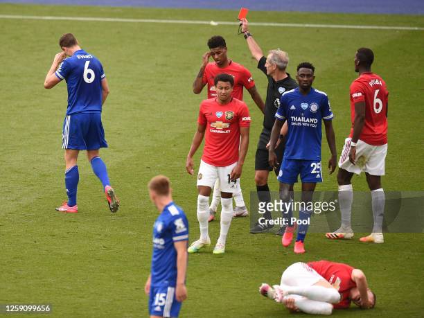 Johnny Evans of Leicester City is shown a red card by referee Martin Atkinson during the Premier League match between Leicester City and Manchester...