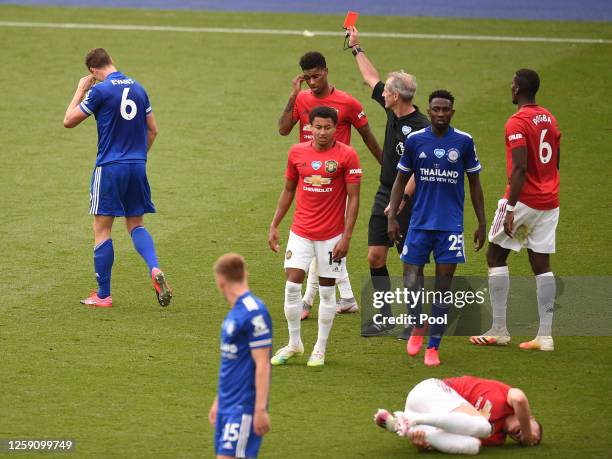 Johnny Evans of Leicester City is shown a red card by referee Martin Atkinson during the Premier League match between Leicester City and Manchester...