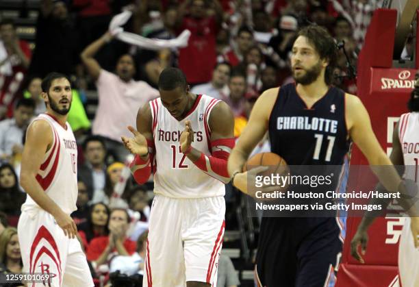 Houston Rockets small forward Omri Casspi left, looks on as teammate Houston Rockets center Dwight Howard center claps and Charlotte Bobcats power...