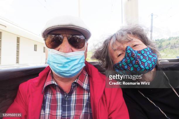 senior couple in train with protective face masks - coronavirus protection stock pictures, royalty-free photos & images
