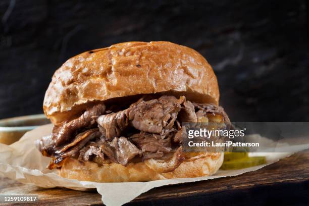 roast beef sandwich with au jus on a toasted onion bun - roast beef dinner stock pictures, royalty-free photos & images