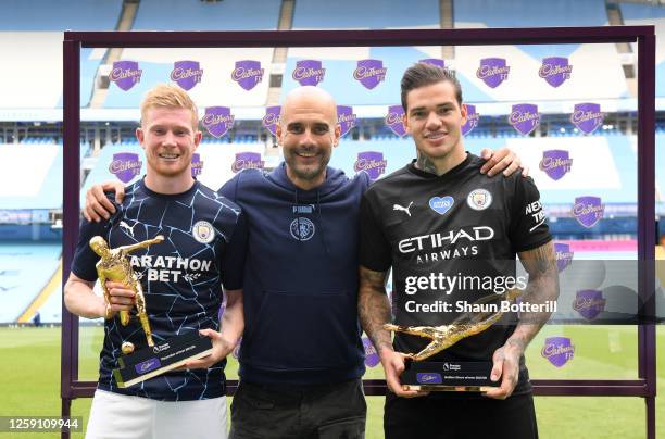 Ederson of Manchester City holds the Golden Glove Award and Kevin De Bruyne of Manchester City holds the Playmaker Award alongside Pep Guardiola,...