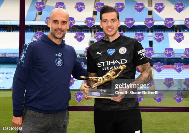 Ederson of Manchester City receives the Golden Glove Award from Pep Guardiola, Manager of Manchester City after the Premier League match between...