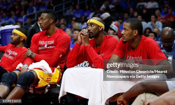 Houston Rockets forward Josh Smith , center Dwight Howard , guard Corey Brewer and forward Trevor Ariza sit on the bench near the end of the second...