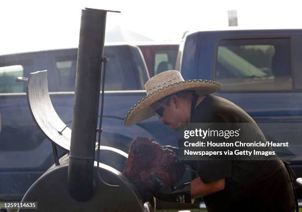 Andy Martinez with Plumbers Union 68 looks over a brisket while cooking on the Los Desperadoz Cookers team during the 2015 Labor Day Celebration &...