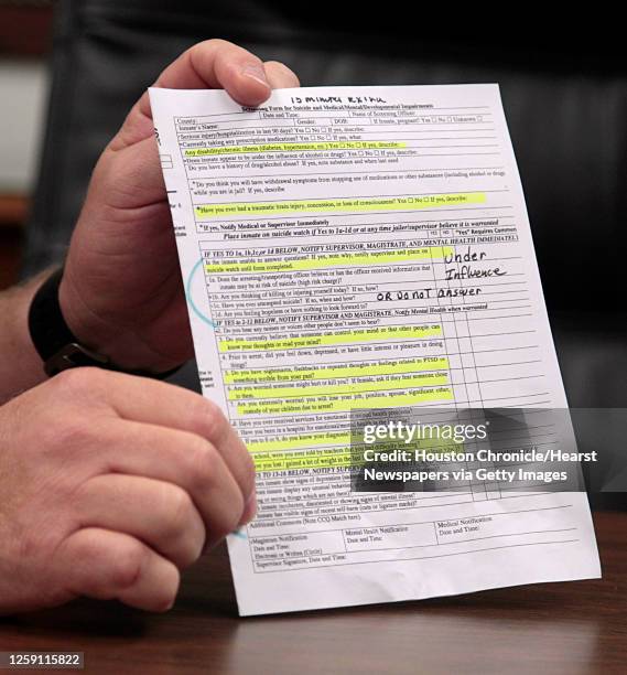 Fort Bend County Sheriff Troy Nehls holds a Screening Form for Suicide and Medical and Mental Impairments during an interview on recent suicides in...