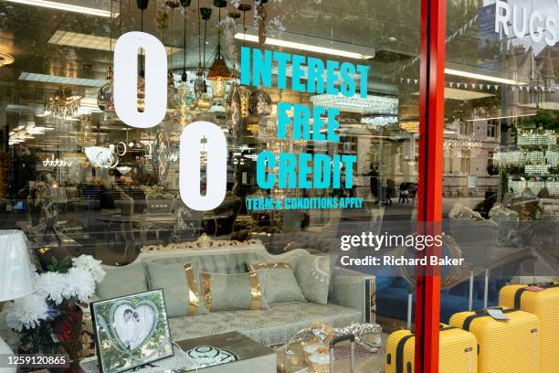 With a portrait of a happy couple in a picture frame, a furniture and home fixtures business advertises interest free credit in ts window in Ealing,...