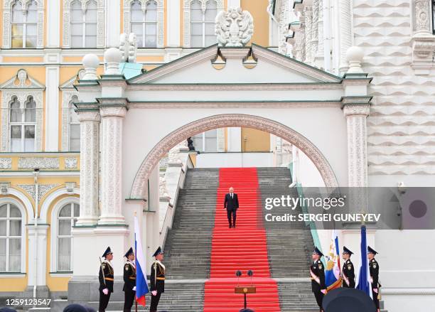 Russian President Vladimir Putin walks down the steps to address troops from the defence ministry, National Guard, FSB security service and interior...