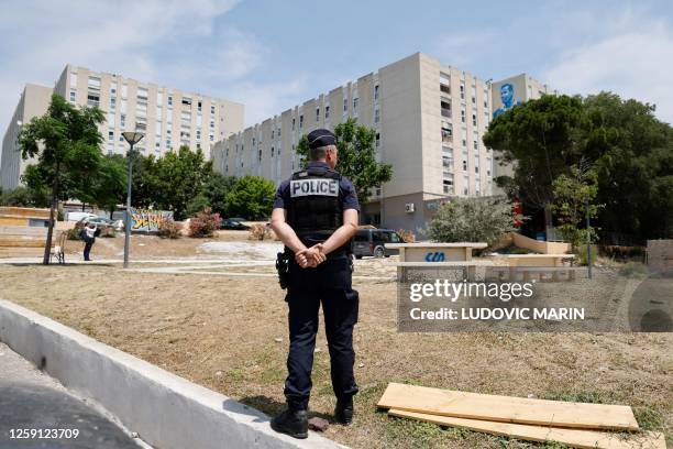 French police officer stands guard at the Cite de la Castellane housing project in the northern district of Marseille, southern France on June 27...