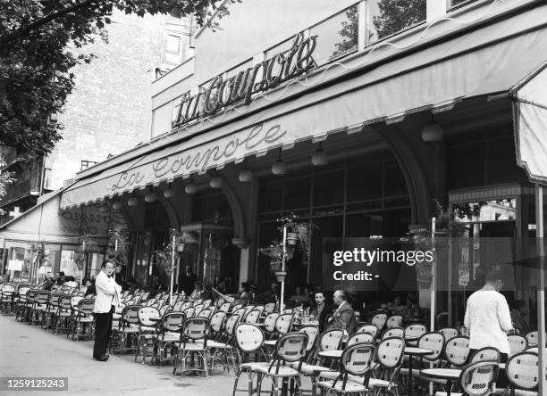 Few customers have a drink on the almost empty terrace of the Parisian Brasserie La Coupole, on June 15, 1949 in the Montparnasse district, left...