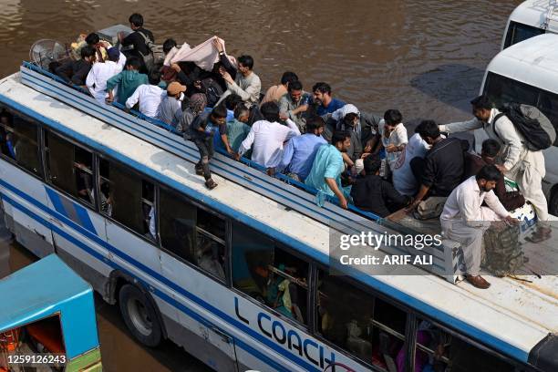 People travel in an overcrowded bus to their hometowns ahead of the Muslim festival Eid al-Adha, in Lahore on June 27, 2023.