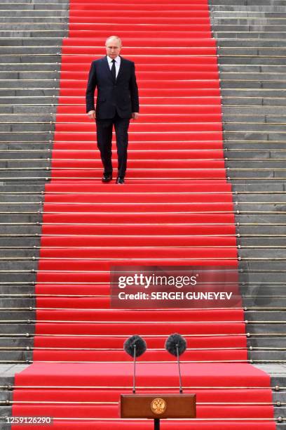 Russian President Vladimir Putin walks down the steps to address troops from the defence ministry, National Guard, FSB security service and interior...