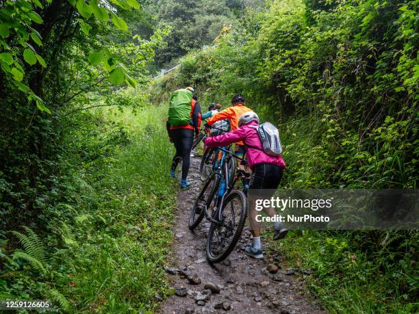 Group of bikers are seen struggling while trying to climb a hill with their bikes during their riding of the Camino Primitivo, in Asturias, Spain. On...