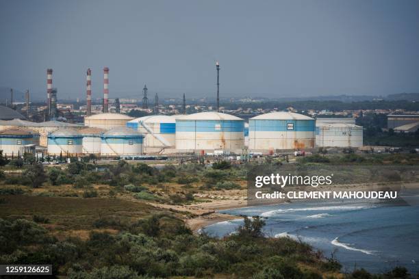 This photograph taken on June 22, 2023 shows the DPF "Depot Petrolier de France" petrol silos and its burning flare tower at the Marseille-Fos...