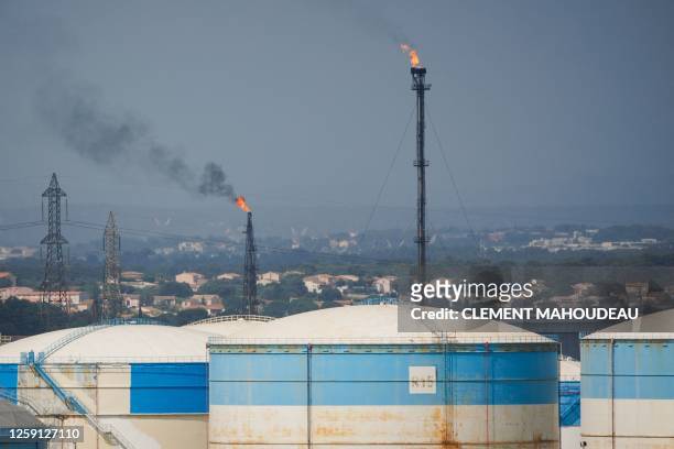 This photograph taken on June 22, 2023 shows the DPF "Depot Petrolier de France" petrol silos and its two burning flare towers at the Marseille-Fos...