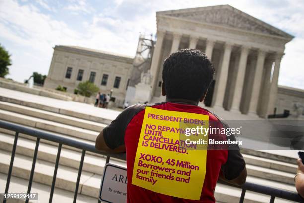 Visitor with a sign regarding student loan payments outside of the US Supreme Court in Washington, DC, US, on Tuesday, June 27, 2023. The Supreme...