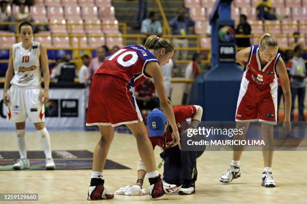 Russia's Ilona Korstin and Oxana Rakhmatulina point to the floor showing a cleaning staff some water coming from a leak on arena's rooftop, during...