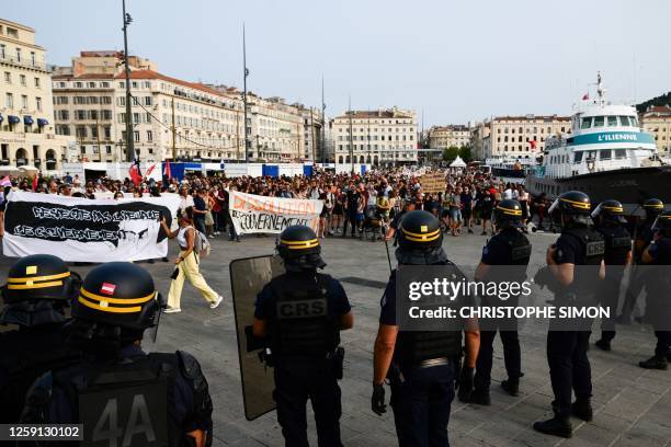 Protestors hold signs facing French anti riot police officers during a gathering organised by the environmental movement "Les Soulevements de la...