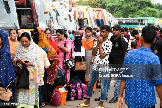 People seen waiting for buses to take them back home to celebrate the Eid-Al Adha festival with their families and friends at the Mohakhali bus...