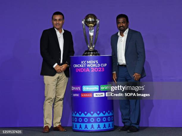 Former Indian cricketer Virender Sehwag and Former Sri Lankan cricketer Muttiah Muralitharan pose for a photo with the men's cricket world cup trophy...