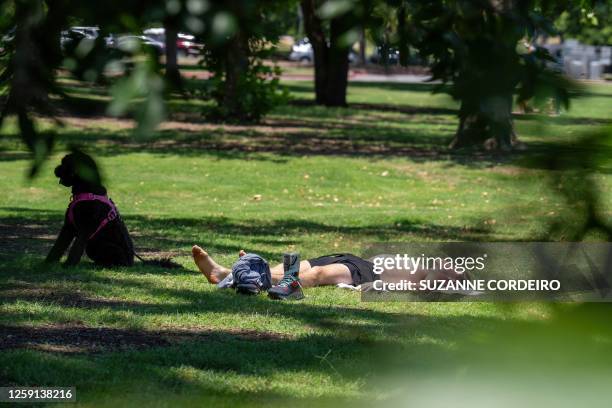 Resident and his dog sunbath at Zilker Park on June 27, 2023 in Austin, Texas. A dangerous and prolonged heat wave blanketed large parts of the...