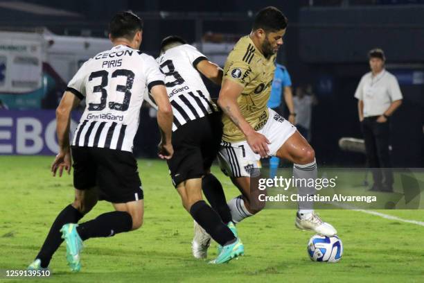 Hulk of Atletico Mineiro controls the ball under pressure of Diego Gomez and Ivan Piris of Libertad during a group G match between Libertad and...