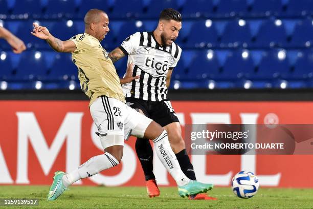 Atletico Mineiro's defender Mariano and Libertad's forward Hector Villalba fight for the ball during the Copa Libertadores group stage second leg...