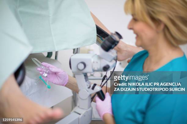 ginecólogo profesional tomando la muestra de cuello uterino de las mujeres durante el examen - cervix fotografías e imágenes de stock