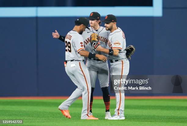 Luis Matos, Bryce Johnson, and Michael Conforto of the San Francisco Giants celebrate a 3-0 win against the Toronto Blue Jays at Rogers Centre on...