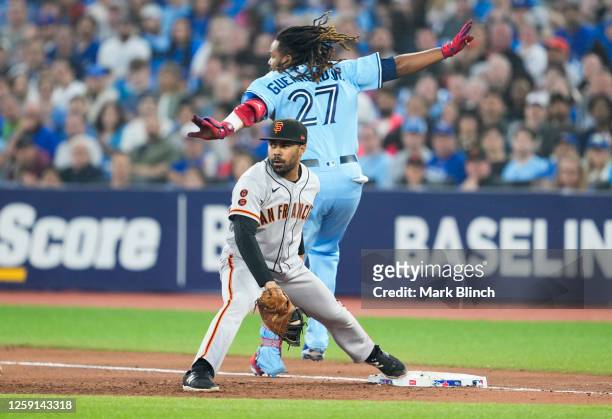 LaMonte Wade Jr. #31 of the San Francisco Giants forces out Vladimir Guerrero Jr. #27 of the Toronto Blue Jays at first base during the sixth inning...